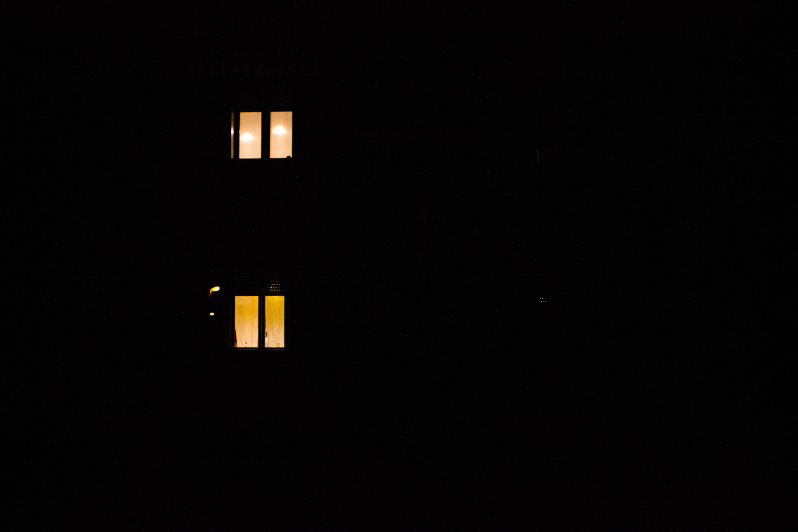 fotografia: due finestre illuminate da una luce gialla, immerse nella notte